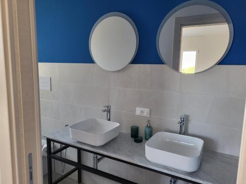 a bathroom with a sink and two mirrors at Casa Villaggio Pirandello in Agrigento