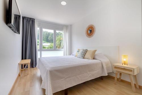 a white bedroom with a bed and a window at Duerming Park Viveiro in Viveiro