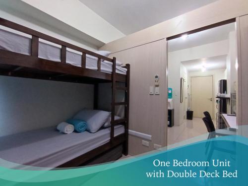 1 dormitorio con literas y baño con 1 cama doble cubierta. en Mint Homes in Jazz Residences Tower B, en Manila