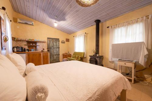 a bedroom with a white bed and a television at Hemdatya Stone Suites In The Galilee in Ilaniya