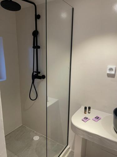 a shower with a glass door next to a sink at Rania Apartments Sea View in Mýkonos City