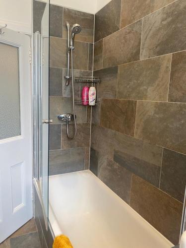Das Bad ist mit einer Badewanne mit einer Dusche ausgestattet. in der Unterkunft Lovely main door 2 bed apartment in Edinburgh