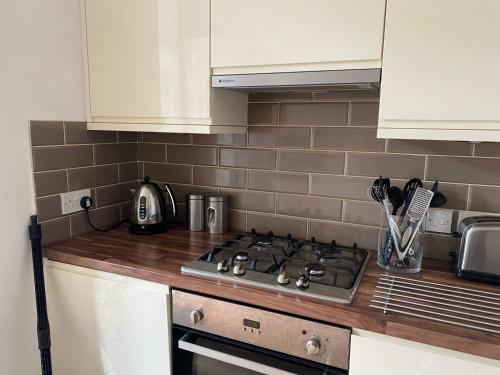a kitchen with a stove and a counter top at Lovely main door 2 bed apartment in Edinburgh