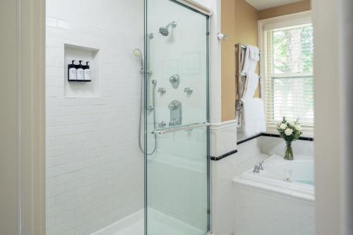 baño con ducha y puerta de cristal en Landmark Inn, en Cooperstown