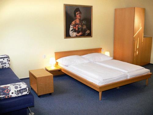 a bedroom with a bed and a picture on the wall at Vinařský dvůr in Valtice