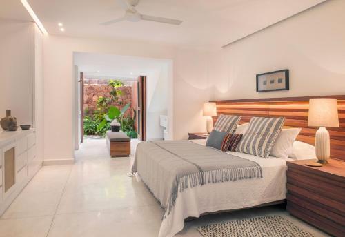 een slaapkamer met een bed en een plafondventilator bij El Careyes Club & Residences in Careyes