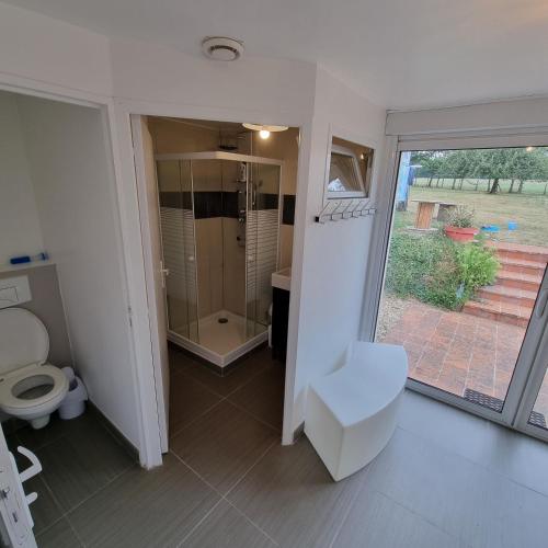 La salle de bains est pourvue de toilettes et d'une porte coulissante en verre. dans l'établissement Chambres Domaine de Saint Marc, à Saint-Médard