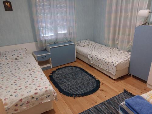 Habitación pequeña con 2 camas y alfombra en villa Tia Maria, en Hisarya