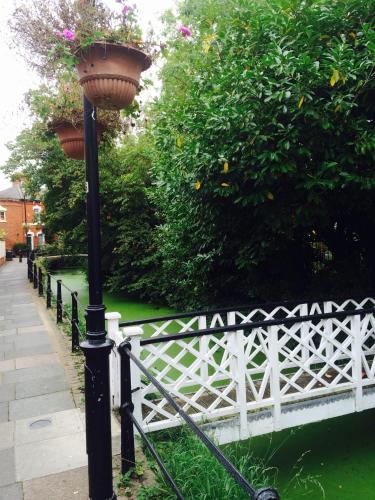 a lamp post with a planter on it next to a white fence at Holtwhites Hotel in Enfield
