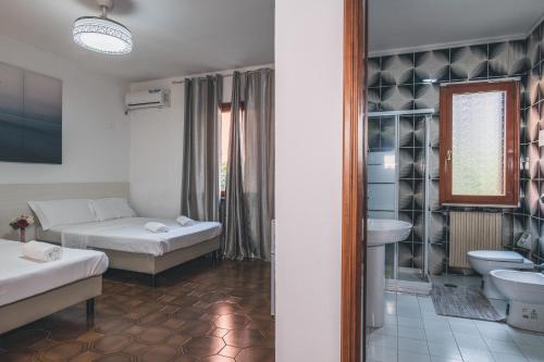 Habitación de hotel con 2 camas y lavamanos en Venice Vacation House, en Mestre