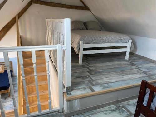 Cette petite chambre comprend un lit et un escalier. dans l'établissement Le saint Exupery, à Saint-Vigor-le-Grand