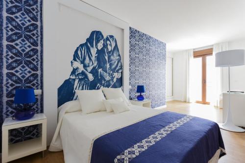 a blue and white bedroom with a large bed at Enlakruz in Lagartera