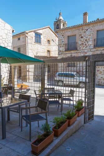 a patio with tables and chairs in front of a building at Enlakruz in Lagartera