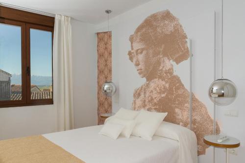 un dormitorio con un retrato de un hombre en la pared en Enlakruz, en Lagartera