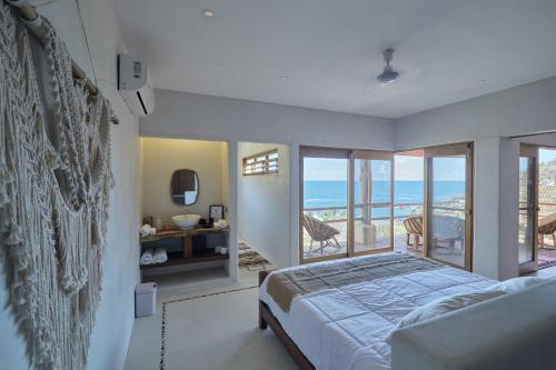 Schlafzimmer mit einem Bett und Meerblick in der Unterkunft Casa Roni - 5 Bedroom Luxury Villa with Ocean View in Playa Estacahuite