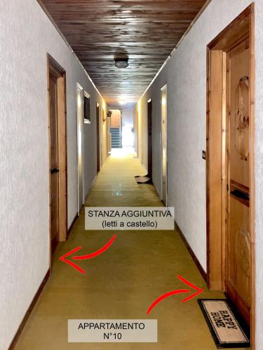 a hallway with two red arrows pointing to the entrance of a building at Appartamento Dimora della Volpe - Terminillo in Terminillo