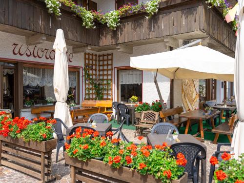a garden area with tables and umbrellas at Hotel Alle Alpi in Alleghe