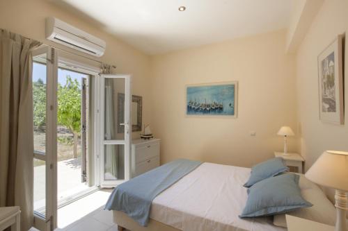 a bedroom with a bed and a sliding glass door at Villa Waterfront in Souvala