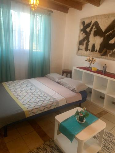 1 dormitorio con 1 cama con cortinas azules y mesa en Majada Blanca en Antigua