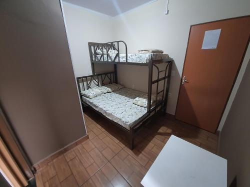 a small room with a bunk bed next to a door at Pousada Pimenta Olimpia in Olímpia
