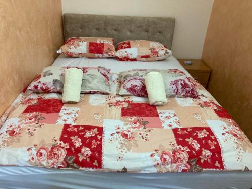 a bed with a red and white quilt and pillows at STAN NA DAN-LOZNICA 2 in Loznica
