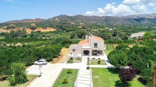 an aerial view of a white house with trees and mountains at Villa Florentina ✩ Private Pool ✩ BBQ ✩ 7 Guests in Alikianós