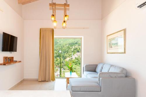 sala de estar con sofá y ventana en Milos Mountain - Villa Nikitas, en Agios Nikitas