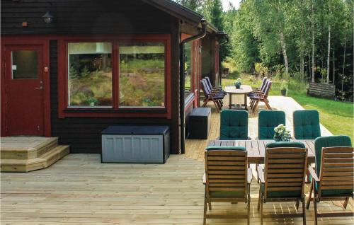 a wooden deck with a table and chairs on a cabin at Awesome Home In Älgarås With Wifi in Hallerud