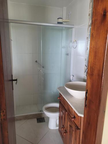 a bathroom with a shower and a toilet and a sink at Cobertura vista mar in Maricá