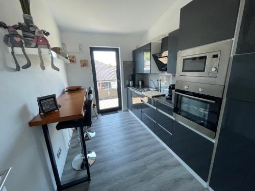 a small kitchen with a table and a microwave at #NEU l Seeblick l NETFLIX l BOXSPRING l NESPRESSO l e-TÜR l Terrasse l 82m2 in Ulmen