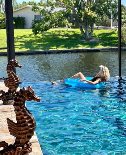 a woman laying on a raft in a swimming pool at Villagoona in Cape Coral