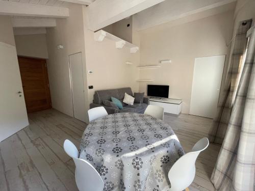 a table and chairs in a living room with a couch at Appartamento Maison Blanche in La Salle