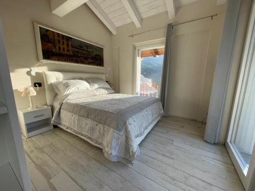 een slaapkamer met een bed en een groot raam bij Appartamento Maison Blanche in La Salle