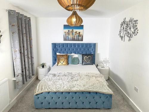 a blue bed in a bedroom with a blue headboard at ☆Igloo MagnoliaView Luxe Townhouse + Free Parking☆ in Leeds