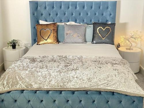a blue bed with a blue headboard and pillows at ☆Igloo MagnoliaView Luxe Townhouse + Free Parking☆ in Leeds