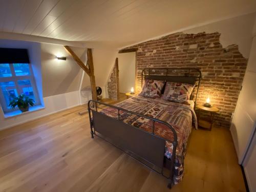 a bedroom with a bed with a brick wall at Loft in der alten Spinnerei in Spechtholzhock