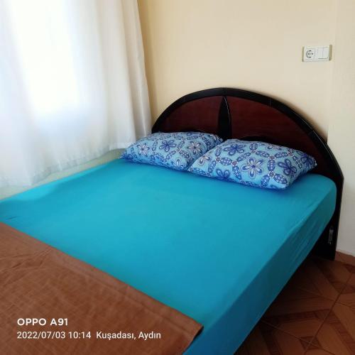 Una cama con dos almohadas azules encima. en Villa, en Kusadasi