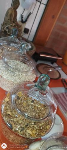 a group of glass containers filled with nuts on a table at Pousada Refugio do Serrano in São Bento do Sapucaí