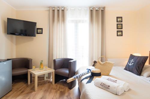 a room with two beds and a flat screen tv at Willa Kapitańska i Willa Marynarska in Łeba