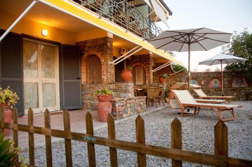 a house with a fence and a patio with an umbrella at Casevacanza Trentovamare in Agropoli