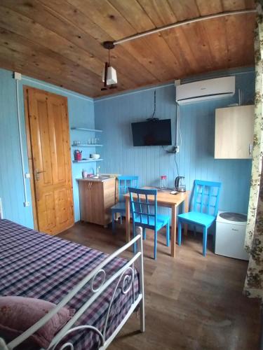 a bedroom with a bed and a table and chairs at Апарт-отель "У речки" in Kuchkisabano