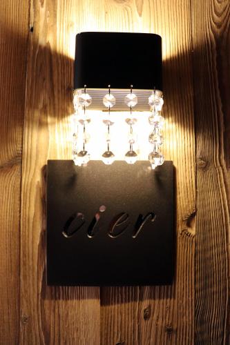 a black sign with wine glasses on a table at Alpine Residence Villa Adler in San Vigilio Di Marebbe