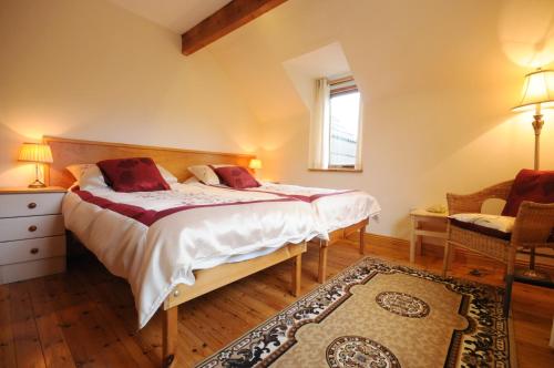 a bedroom with a bed and a chair and a window at Lough Dan House in Oldbridge