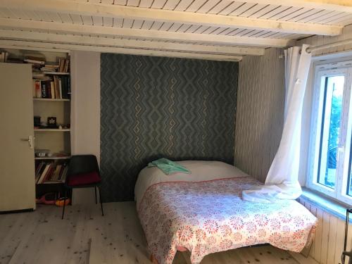 een kleine slaapkamer met een bed en een raam bij Treacy’s résidence in Morez