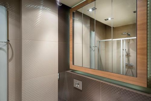 a bathroom with a large mirror and a shower at Lux modern apartment in Krakow