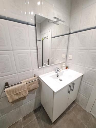 a white bathroom with a sink and a mirror at Gijon playa cerca, Wifi y parking - VUT-1523AS in Gijón