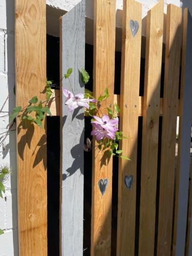 a wooden fence with flowers and hearts on it at Luises Ferienglück in Vernawahlshausen