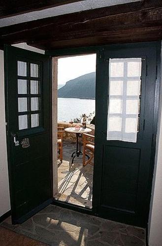 a door to a room with a view of the ocean at Lazareto Hotel in Monemvasia