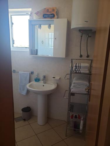 a small bathroom with a sink and a mirror at Apartmani Čiklić in Dobropoljana