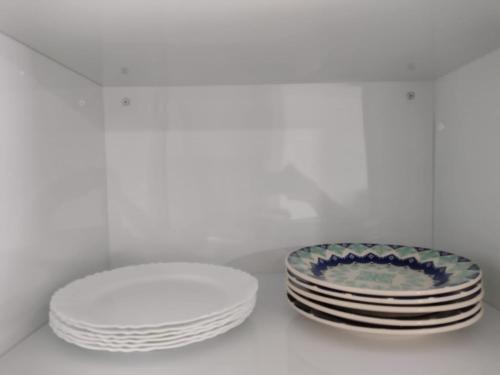 a stack of plates and a stack of plates on a shelf at Casa Premium em Bonito - Linda e Confortável in Bonito